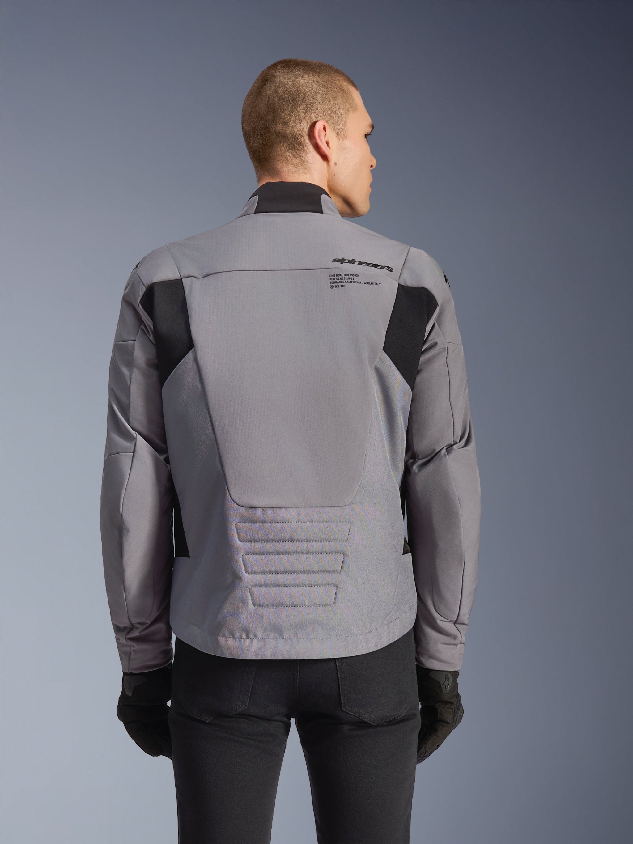 Alpinestars SMX Waterproof Jacket, Gray with black accents, back view showing upper back branding and elongated rear profile, worn by a model with black pants and gloves