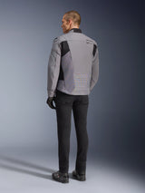 Alpinestars SMX Waterproof Jacket in Dark Gray and Black, rear view on a model, worn with black pants and boots, featuring technical textile construction with black panels and Alpinestars branding on the shoulder.