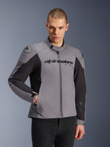 Alpinestars SMX Waterproof Jacket, Dark Gray and Black, worn by a male model, featuring 'alpinestars' branding on the chest, DFS Lite shoulder protection, sleek sport design with textile and softshell materials for road riding.