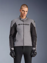 Alpinestars SMX Waterproof Jacket, Sport Road Motorcycle Jacket, Dark Gray and Black, featuring a high collar and DFS Lite shoulder sliders, worn with black SMX gloves, sleek athletic fit for all-weather riding