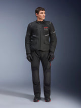Male model wearing Alpinestars Andes Air Drystar® Jacket in Black, adventure touring motorcycle gear with matching pants and gloves, featuring red logo on the chest, mesh ventilation, and functional pockets.
