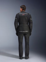 Alpinestars Andes Air Drystar® Jacket and Pants, Black motorcycle touring outfit, rear view of rider, featuring mesh panels, red star logo, and reflective alpinestars branding on the jacket, worn with black gloves and boots.