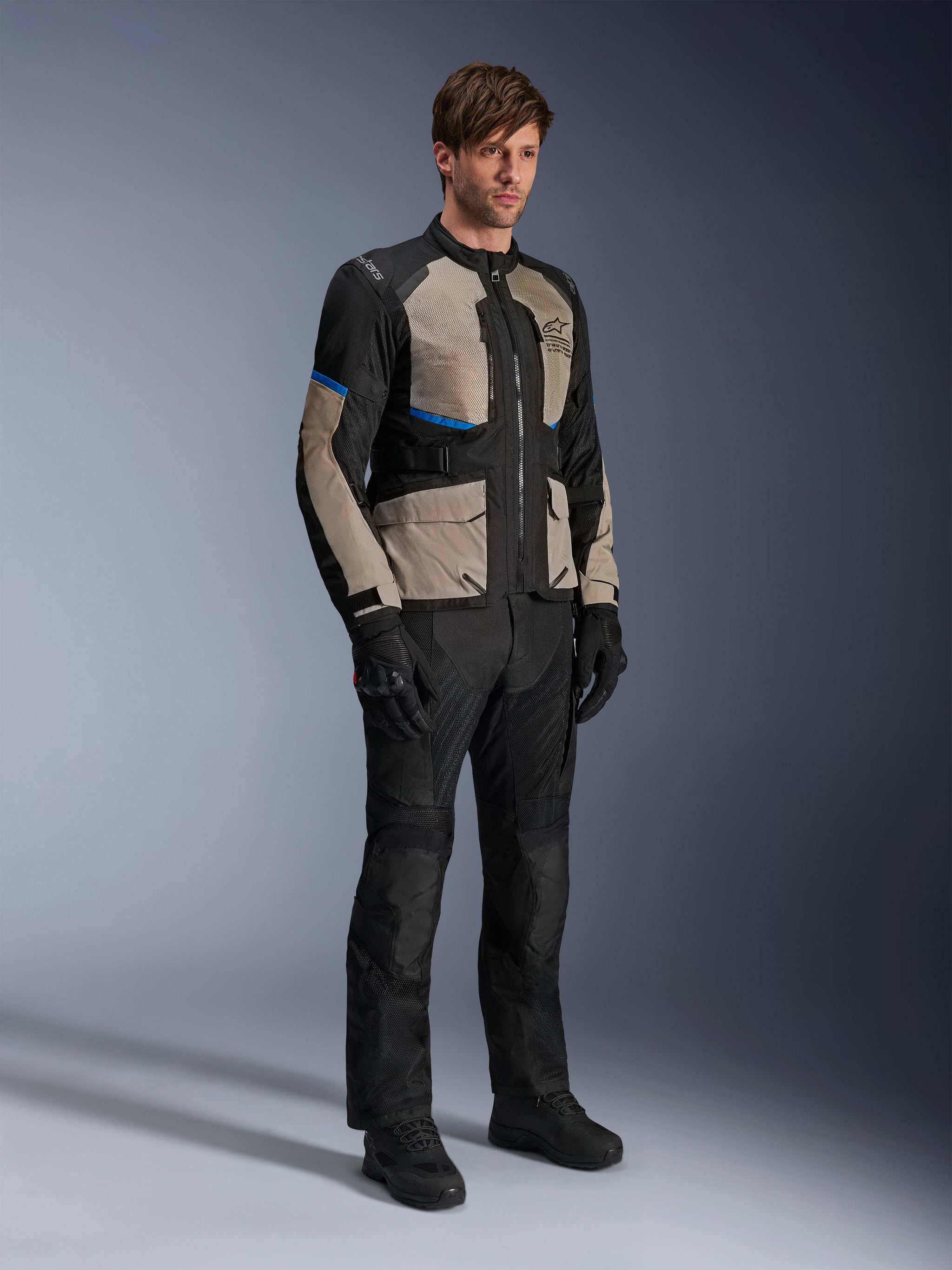 Alpinestars Andes Air Drystar® Jacket, Motorcycle Touring Jacket, Black Laurel Gray and Bright Blue, worn with matching riding pants and gloves, featuring extensive mesh panels for airflow and a road-oriented fit, adventure touring gear
