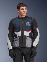 Alpinestars Andes Air Drystar® Jacket, Motorcycle Touring Jacket, Deep Blue, Black, and Ice Gray with Red accents, worn by a male model with black gloves, featuring mesh ventilation panels and front utility pockets, modern adventure and road riding gear