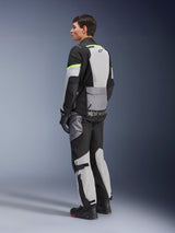 Rider wearing Alpinestars Andes Air Drystar® Jacket and Pants, adventure touring gear in Ice Gray Dark Gray Black with neon yellow accents, featuring extensive mesh panels for airflow, Alpinestars branding on the back, worn with black gloves and boots.