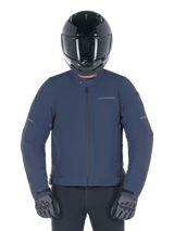 Alpinestars Husker Waterproof Jacket, Night Navy, urban motorcycle jacket worn with a black full-face helmet and grey gloves, featuring a technical softshell exterior and subtle branding