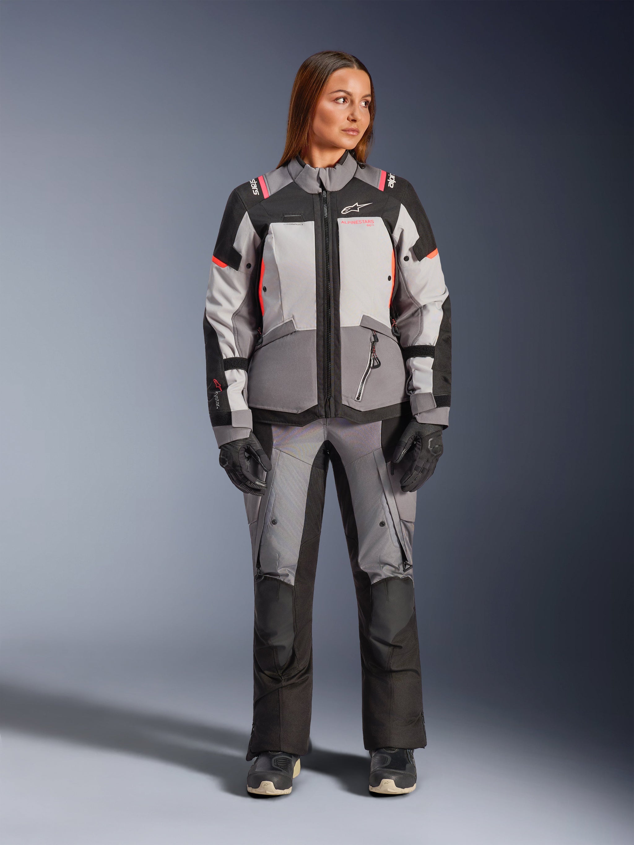 Alpinestars Stella Andes V4 Drystar® Jacket, Women's Adventure Motorcycle Jacket, Dark Gray Ice Gray and Black with Coral Fluo accents, worn as a complete suit with matching pants and gloves, front full-body view