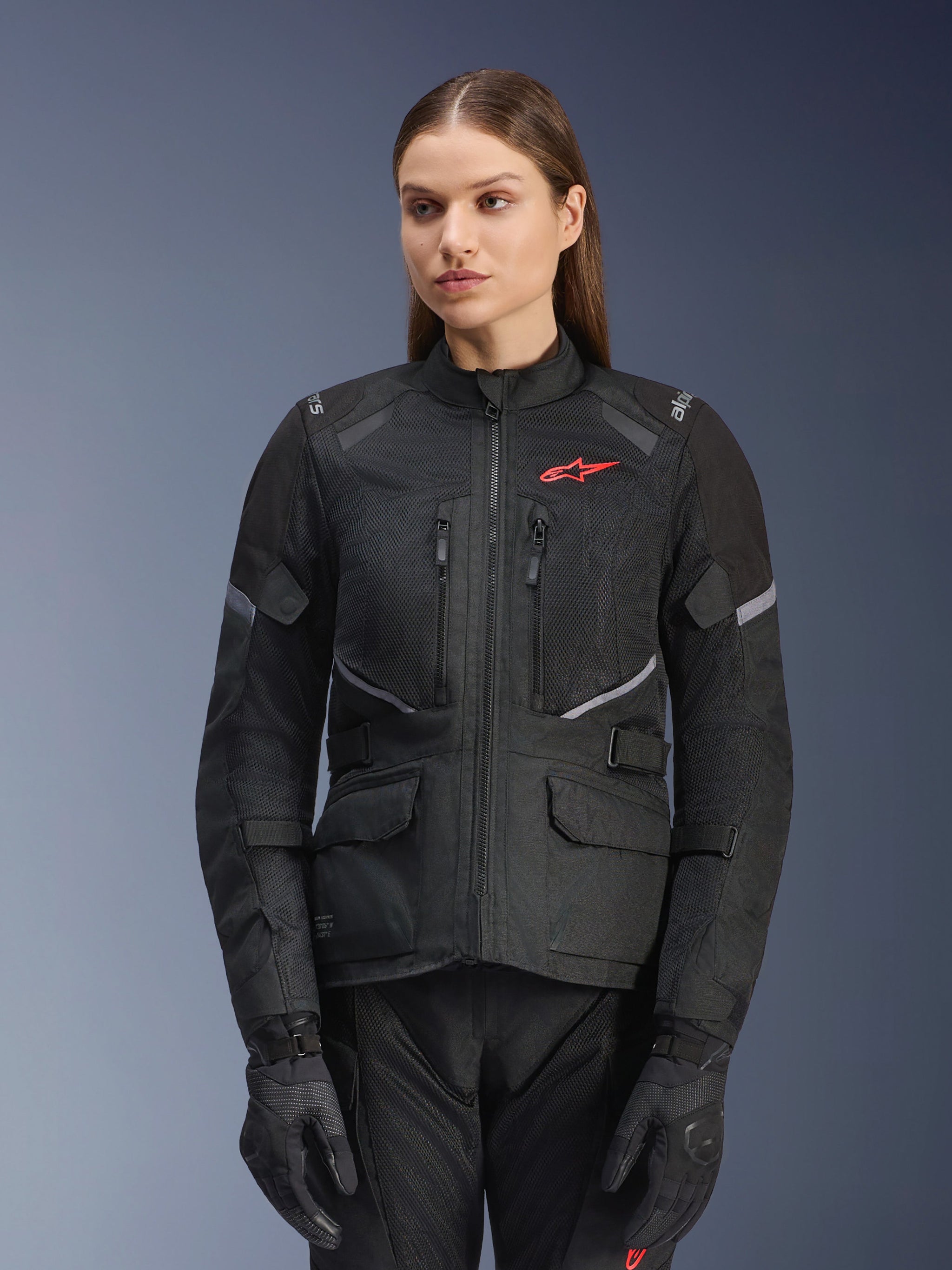 Alpinestars Stella Andes Air Drystar Jacket, Women's Motorcycle Touring Jacket, Black with gray accents and a small red logo, featuring mesh ventilation panels, a high collar, and multiple utility pockets, worn with matching riding gloves and pants
