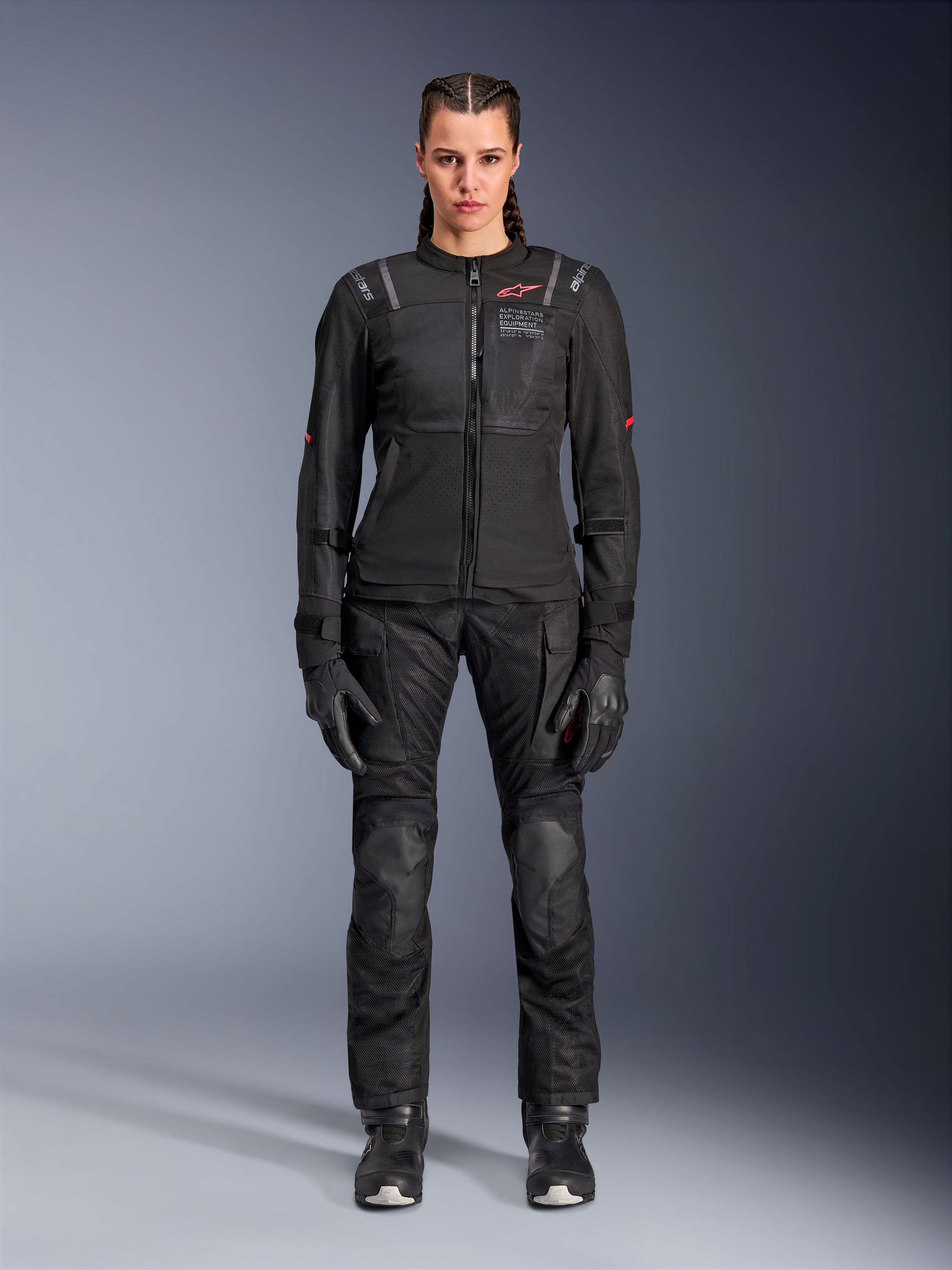 Alpinestars Stella ST-2 Air Jacket, Black, full-body studio view of a female rider wearing matching black motorcycle pants and gloves, featuring high-flow mesh panels, red logo details, and a modern touring design