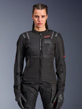 Alpinestars Woman Stella ST-2 Air Jacket, Women's Motorcycle Jacket, Black, front view on model, featuring mesh panels, red logo on chest, and Alpinestars Exploration Equipment branding, worn with black gloves and riding pants