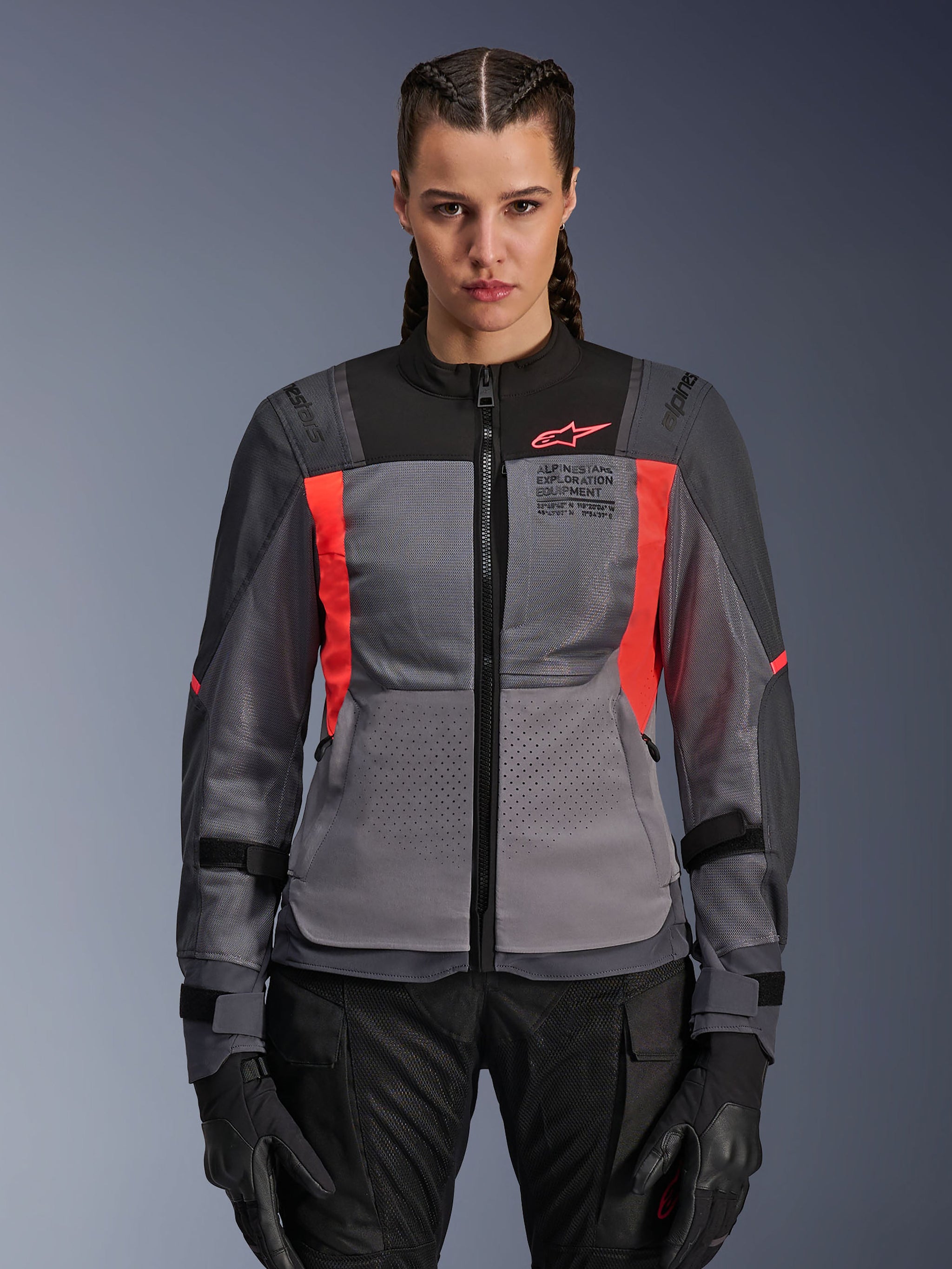 Alpinestars Stella ST-2 Air Jacket, Women's Motorcycle Jacket, Deep Gray and Fluo Coral, model wearing ventilated textile jacket with mesh panels, bright coral accents and chest branding, modern adventure riding style