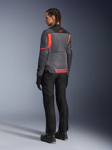 Woman wearing the Alpinestars Stella St-2 Air Jacket, Motorcycle Touring Jacket, Deep Gray and Dark Gray with Fluo Coral accents, styled with black riding pants and gloves, back view showing large mesh panels and reflective coral branding, designed for summer riding adventures