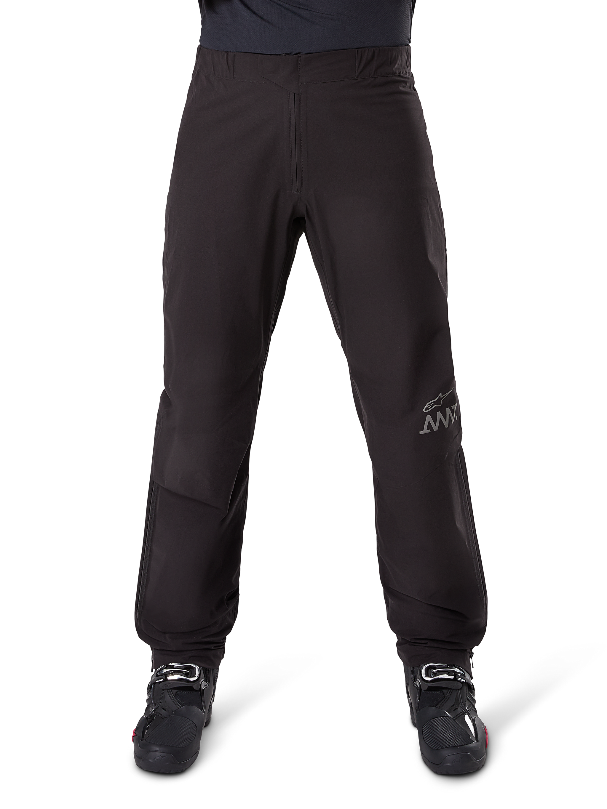 Alpinestars AMT-8 Stretch Drystar® XF Pant Liner, Black, front view worn with black motorcycle boots, featuring grey star logo and AMT branding on the leg, versatile waterproof and windproof motorcycle apparel