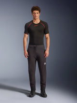 Alpinestars Aeroshell Pants, Black motorcycle softshell pants, worn with a black short-sleeved base layer and black shoes, featuring an elastic drawstring waist, white Astars logo on the thigh, and elastic cuffs, modern athletic silhouette for road riding