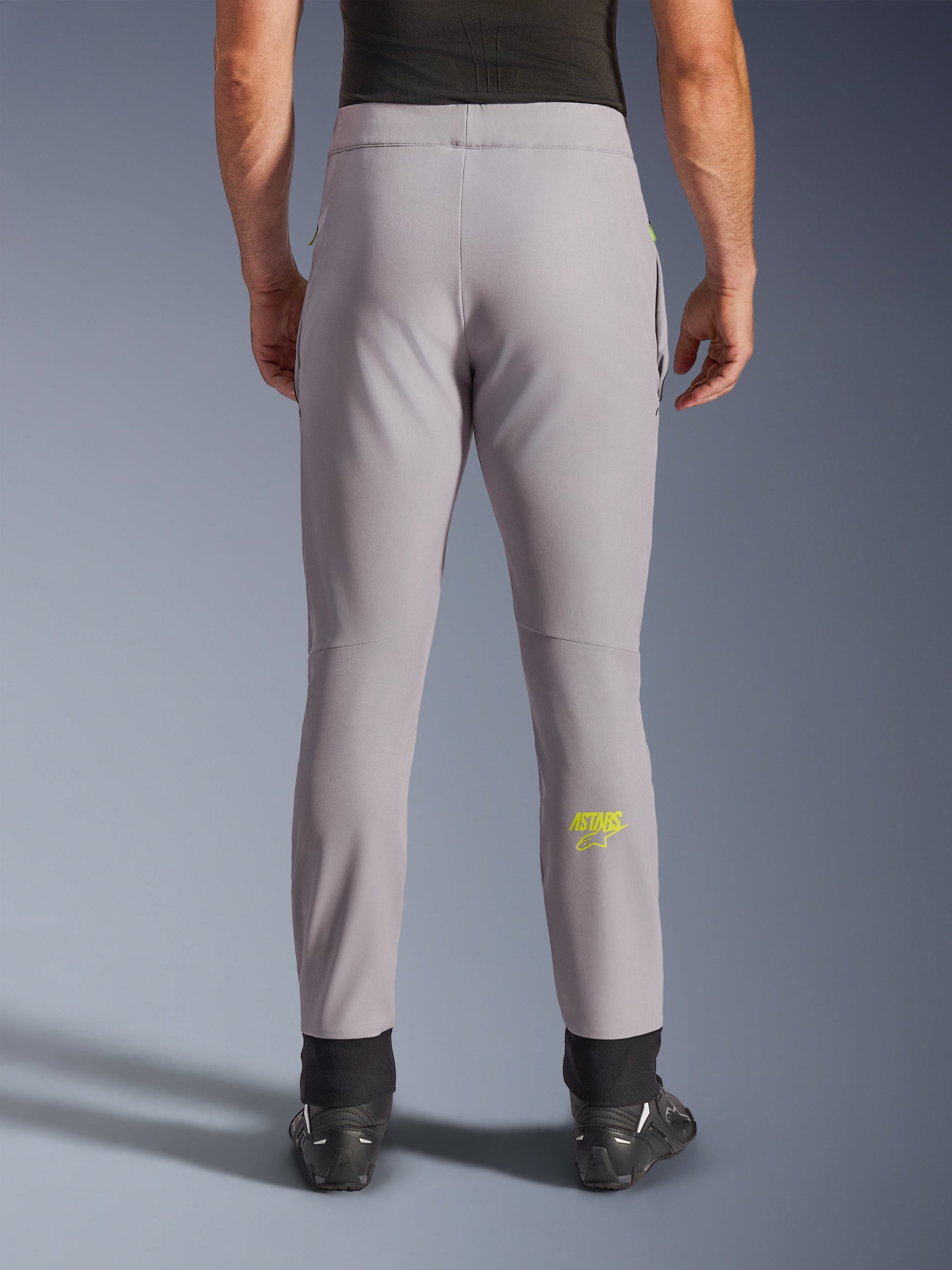 Alpinestars Aeroshell Pants, Motorcycle Pants, Mid Gray and Yellow Fluo, back view showing yellow Astars logo on the calf, black elastic ankle cuffs, modern softshell textile design for road and casual riding.