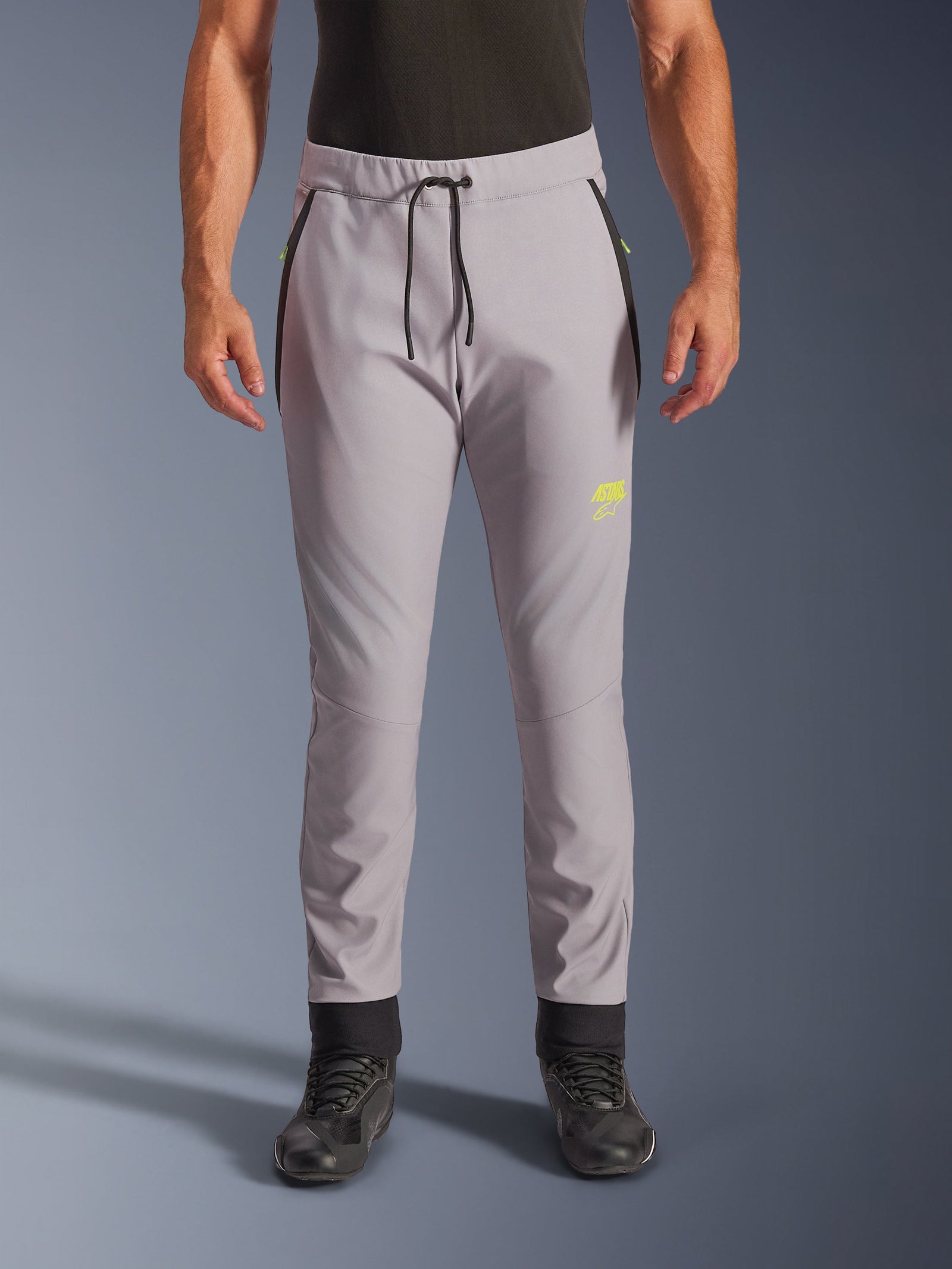 Alpinestars Aeroshell Pants, Mid Gray and Yellow Fluo, crossover softshell motorcycle pants, featuring a black drawstring waist and fitted ankle cuffs, yellow logo on left thigh, pre-curved knees, sporty jogger-style silhouette