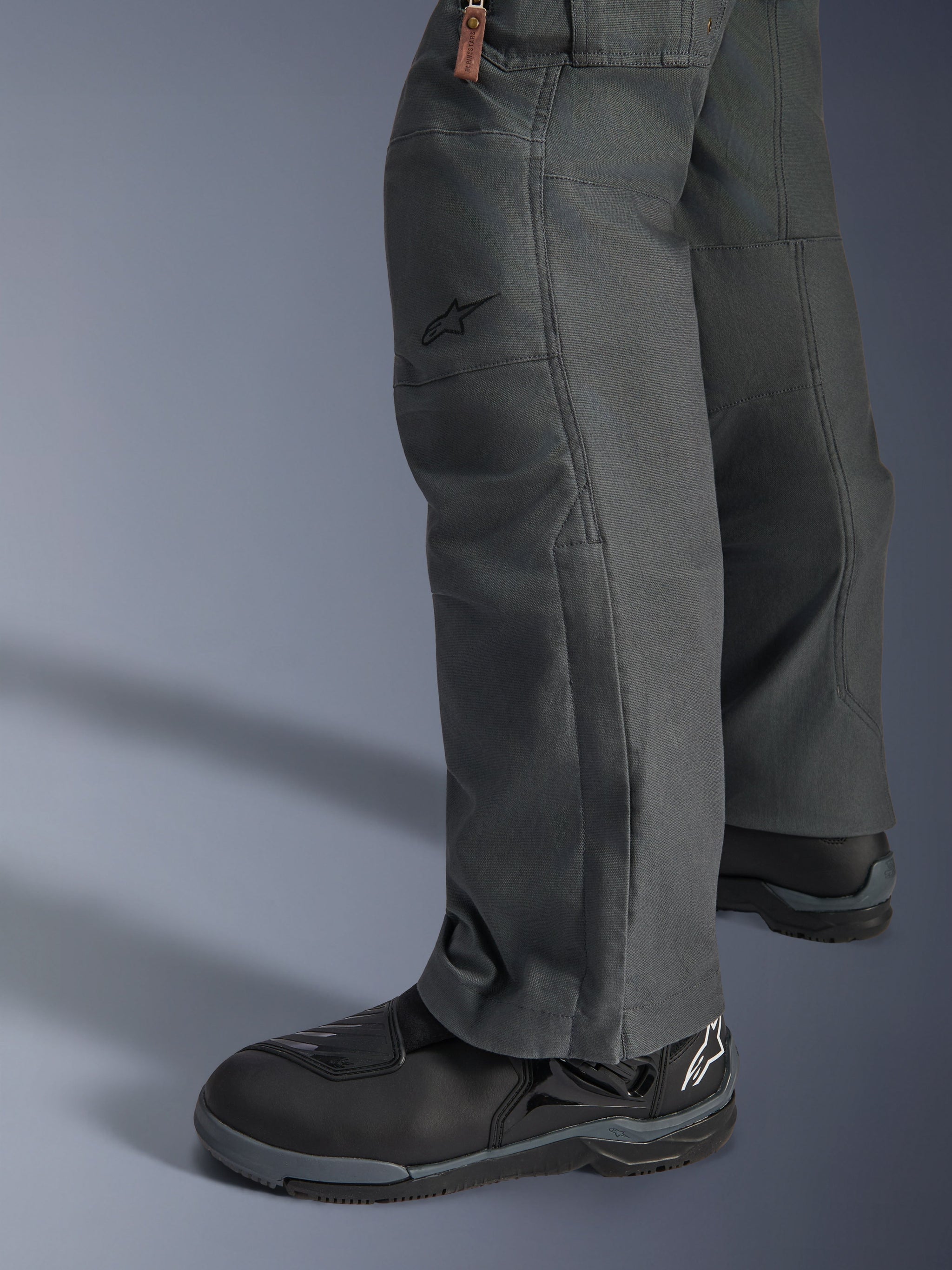 Alpinestars Borrego Drystar® Pants, Anthracite Gray adventure motorcycle pants with a waxed-canvas appearance, textile construction shown from the side with black riding boots, rugged design for road and adventure touring