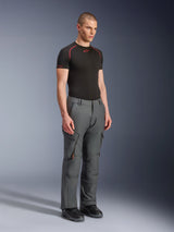 Male model wearing Alpinestars Borrego Drystar® Pants, Gray Anthracite adventure motorcycle pants, workwear-inspired design with cargo pockets and zippered vents, styled with a black short-sleeve base layer and black boots