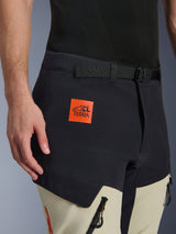 Alpinestars Halo Pro Drystar® XF Laminated Pants, Adventure Motorcycle Pants, Mastic Black and beige, close-up showing the orange 'ALL TERRA' logo patch, black adjustable waist belt, and durable technical fabric with waterproof zippers.