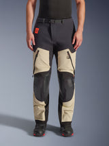 Alpinestars Halo Pro Drystar® XF Laminated Pants, Adventure Motorcycle Pants, Mastic Black, front view worn by a rider, featuring large zippered thigh vents, reinforced black knee panels, and tan textile construction, paired with black and red riding boots