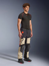 Alpinestars Halo Pro Drystar® XF Laminated Pants in Mastic Black, adventure motorcycle pants worn by a model, featuring black knee and seat reinforcements, orange branding, and multiple functional zippers, styled with a black base layer and riding boots.