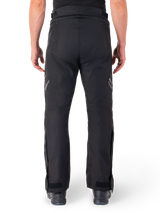 Alpinestars St-1 Waterproof Pants, Motorcycle Touring Pants, Black, back view showing reflective detailing on thighs and adjustable ankle closures, worn with black boots, minimalist design for all-weather road and adventure riding