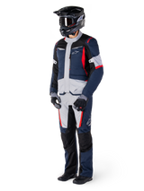 Alpinestars St-1 Waterproof Pants, Adventure Touring Pants, Dark Blue, Black, and Bright Red, worn with a matching touring jacket, black helmet, gloves, and boots, featuring light grey panels, red accents, and Alpinestars branding, designed for all-weather riding.