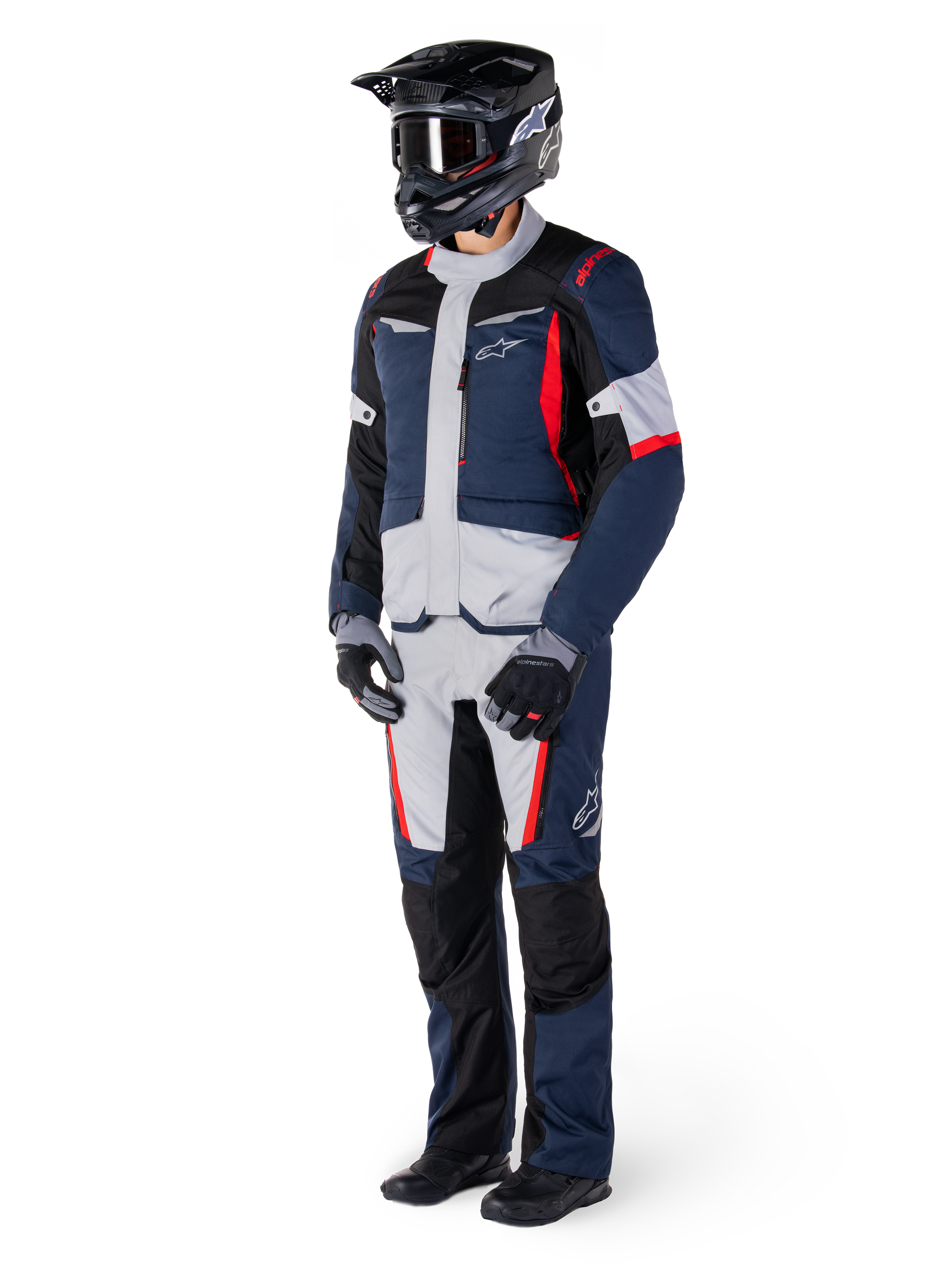 Alpinestars St-1 Waterproof Pants, Adventure Touring Pants, Dark Blue, Black, and Bright Red, worn with a matching touring jacket, black helmet, gloves, and boots, featuring light grey panels, red accents, and Alpinestars branding, designed for all-weather riding.
