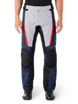 Alpinestars ST-1 Waterproof Pants, Motorcycle Touring Pants, Dark Blue and Light Gray with Bright Red Accents, Black Reinforced Knee Panels, Front View Worn with Black Boots, Waterproof Adventure Touring Gear