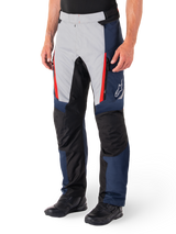 Alpinestars St-1 Waterproof Pants, Motorcycle Touring Pants, Dark Blue Black and Bright Red, featuring light grey front panels with red zipper accents, black reinforced knee sections, and a white Alpinestars logo on the side, worn with black motorcycle boots.