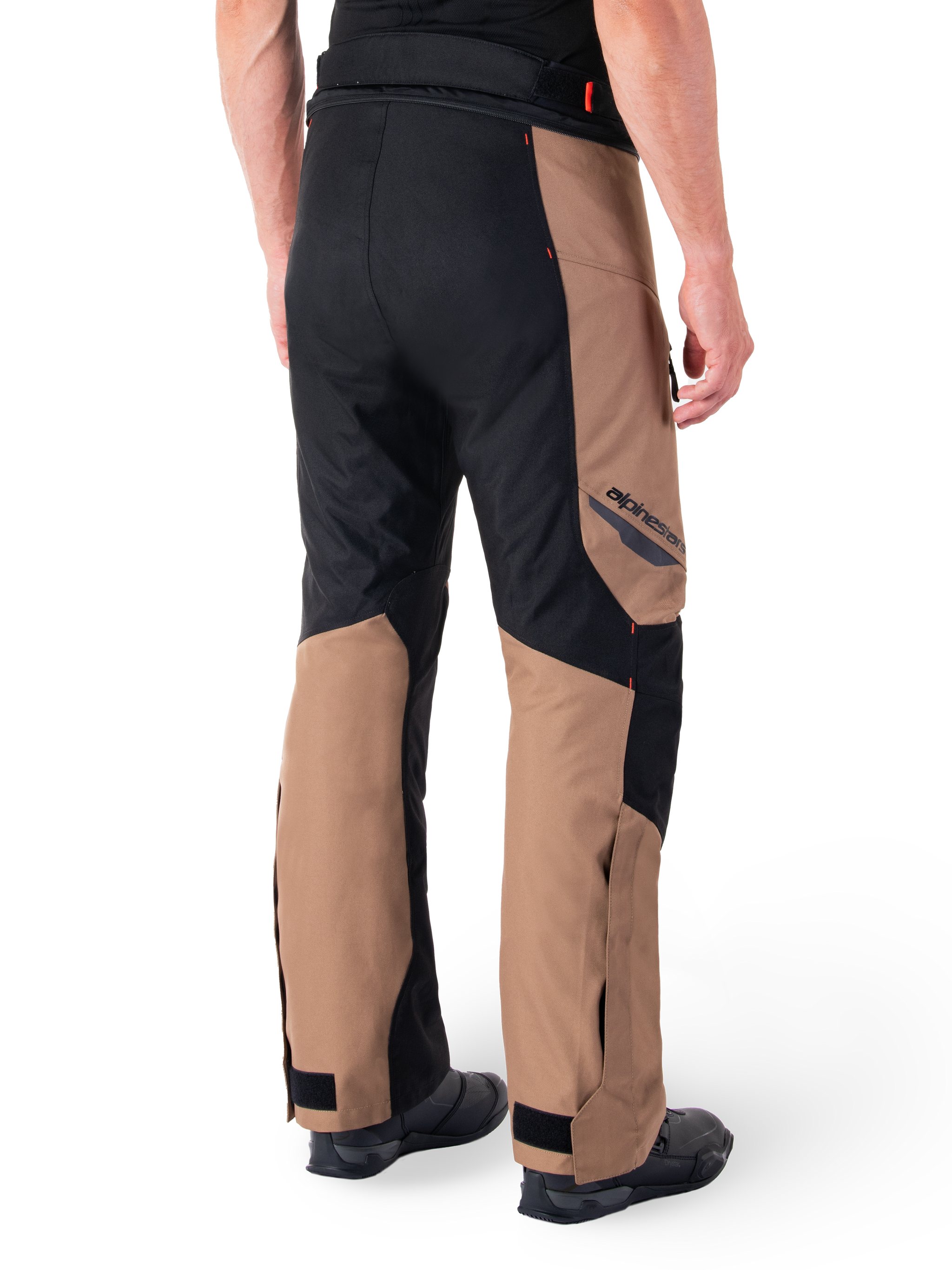 Alpinestars St-1 Waterproof Pants, Motorcycle Touring Pants, Dark Khaki Sand and Black with Red Fluo accents, rear three-quarter view, featuring Alpinestars branding on the thigh and adjustable ankle straps, worn with black boots.