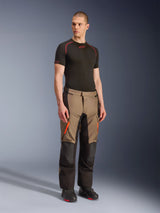 Alpinestars Andes V4 Drystar® Pants, Motorcycle Adventure Touring Pants, Walnut Black with orange accents, worn by model with black short-sleeve base layer and black boots, featuring reinforced textile panels and cargo pockets, rugged design for all-weather riding