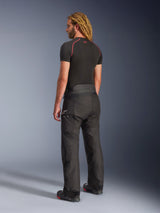 Alpinestars Andes V4 Drystar® Pants, Black motorcycle adventure touring pants, worn by a model from a rear-side view, featuring a white Alpinestars logo on the hip, paired with a black short-sleeve base layer and riding boots, durable textile construction for road and adventure use.