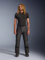 Alpinestars Andes V4 Drystar® Pants, Black adventure motorcycle pants, worn with a black short-sleeved base layer and riding boots, featuring reinforced panels and cargo pockets, durable textile construction for all-weather use