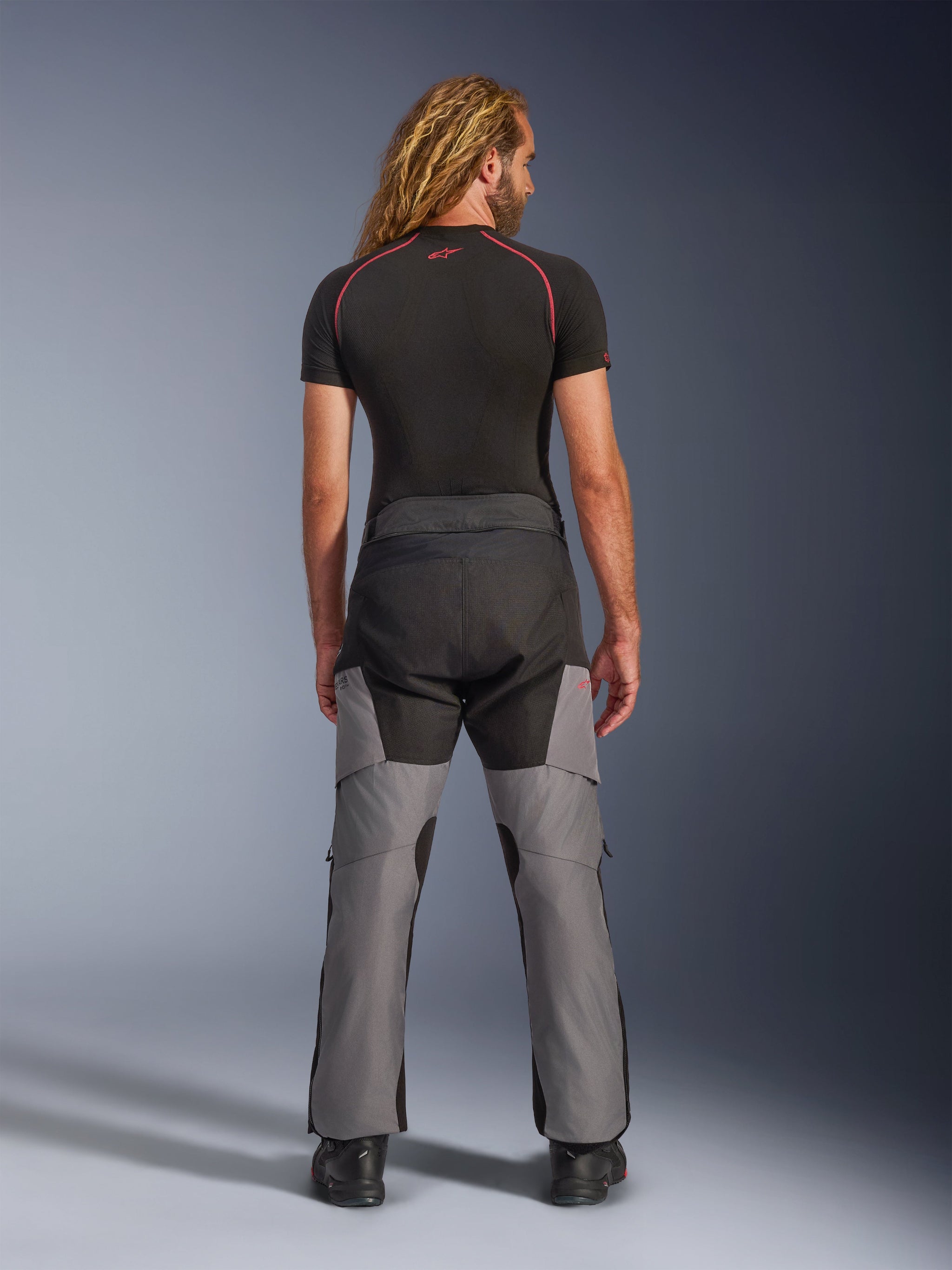 Alpinestars Andes V4 Drystar® Pants, Motorcycle Adventure Pants, Black and Dark Gray, rear view worn by a model, featuring reinforced textile panels on the seat and legs, designed for all-weather touring and commuting.