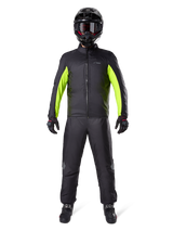 Alpinestars Bogota Pro Drystar 3 Seasons Pants, Black, worn by a motorcycle rider in a full adventure outfit including a black and neon yellow waterproof jacket, black helmet, and riding boots, designed for all-weather touring performance.