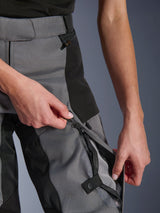 Alpinestars Woman Stella Andes V4 Drystar® Pants, Black and Dark Gray, close-up of hands opening the zippered thigh ventilation vent to reveal breathable mesh, waterproof coil zippers, durable textile construction for adventure riding