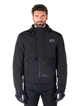 Alpinestars Mootant Waterproof Parka, Black hooded motorcycle jacket with a modular technical design, worn by a male model with black gloves, featuring a unique chest flap and zippered side pockets, urban and touring riding style.