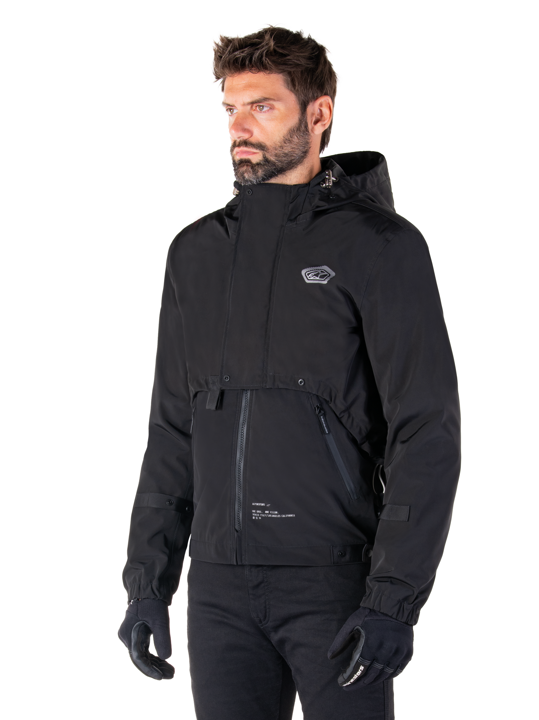 Alpinestars Mootant Waterproof Parka, Black modular motorcycle jacket, worn by a man with black gloves and pants, features a hood, front zipper, and layered utilitarian design, sleek urban aesthetic with logo on chest.