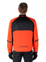 Alpinestars Mootant Waterproof Parka, Motorcycle Jacket, Spicy Orange and Black, Rear View, featuring black mesh upper back and orange lower panel with MO.ST.EQ. logo, worn with black pants and gloves
