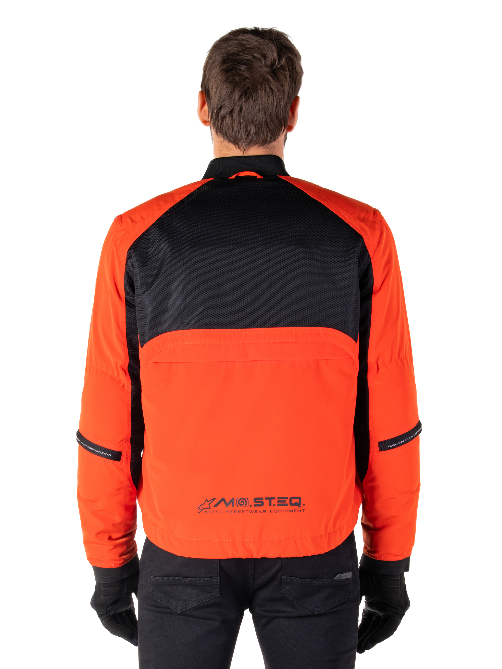 Alpinestars Mootant Waterproof Parka, Motorcycle Jacket, Spicy Orange and Black, Rear View, featuring black mesh upper back and orange lower panel with MO.ST.EQ. logo, worn with black pants and gloves