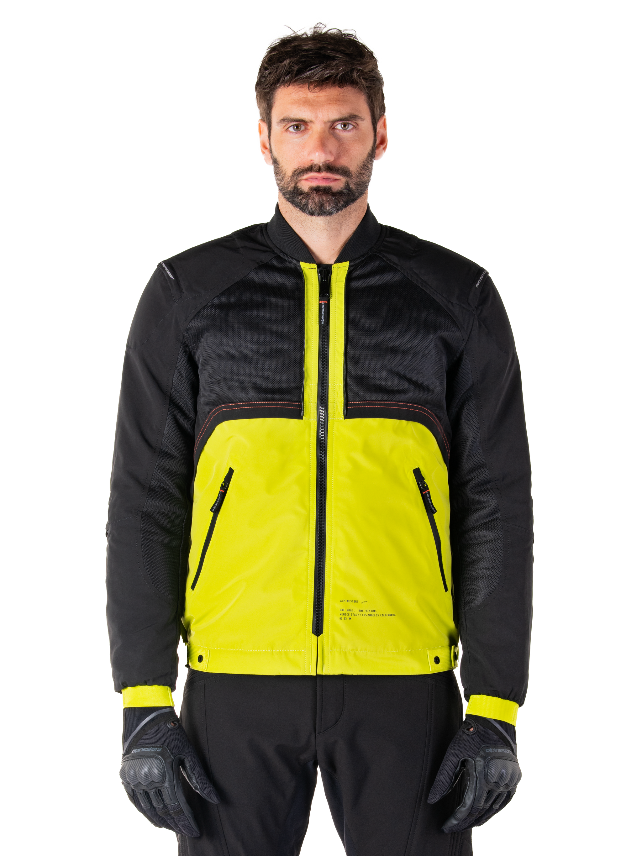 Mootant Waterproof Parka, modular motorcycle jacket, Lime Punch and Black, worn by a male model with black gloves and pants, featuring a vibrant yellow lower body and black upper torso and sleeves, utilitarian design for all-weather riding