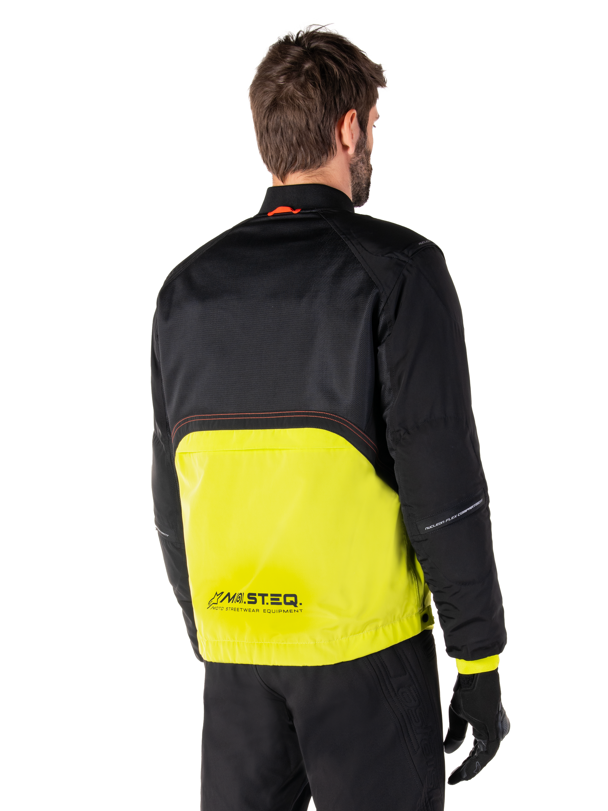 Alpinestars Mootant Waterproof Parka, Motorcycle Jacket, Lime Punch and Black, back view showing black upper mesh and bright lime green lower section, featuring MO.ST.EQ. branding, worn with black riding pants and gloves