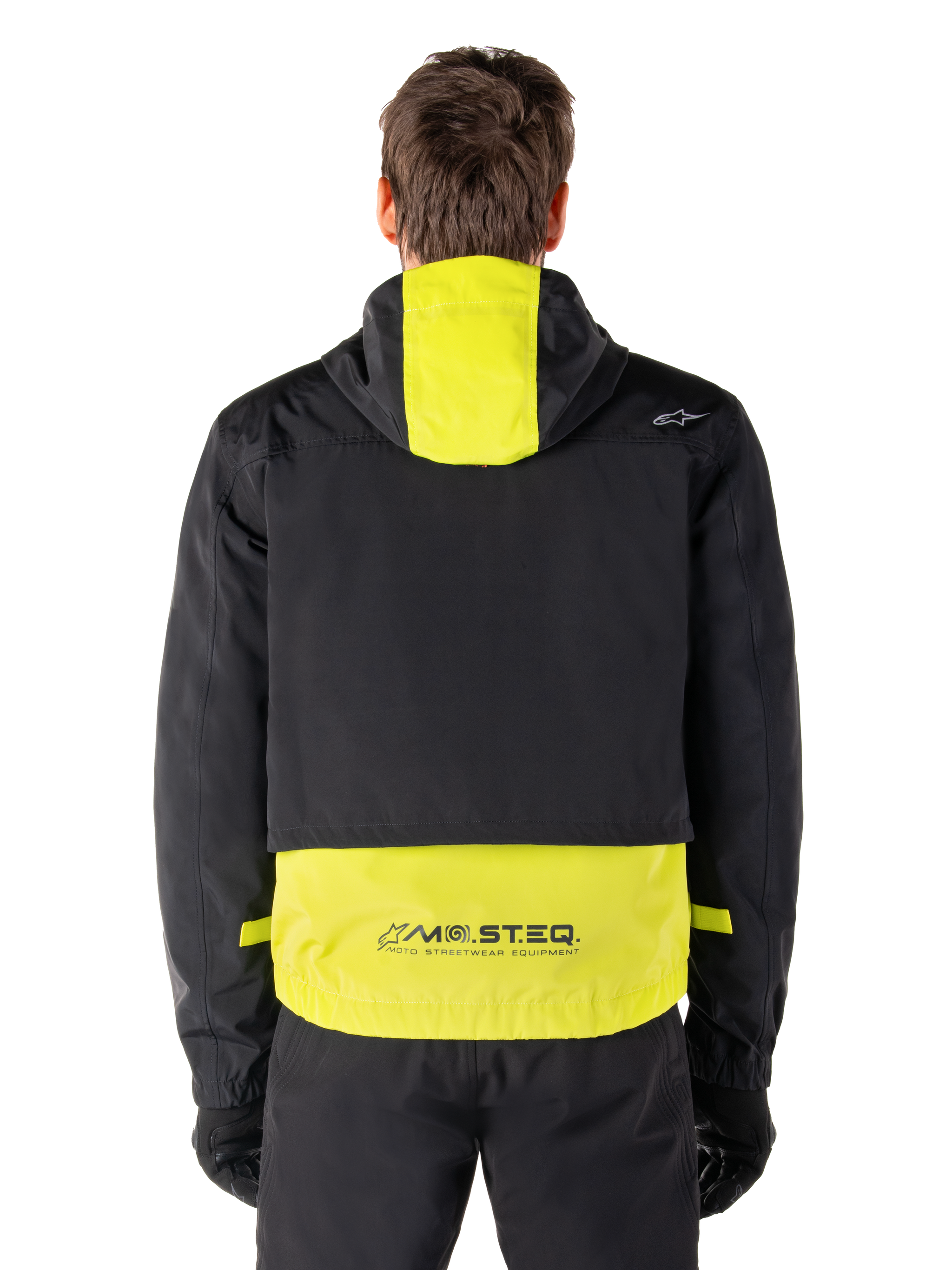 Alpinestars Mootant Waterproof Parka, Motorcycle Jacket, Lime Punch and Black, rear view showing hooded design and reflective MO.ST.EQ. branding on the lower back, worn with black riding pants and gloves.