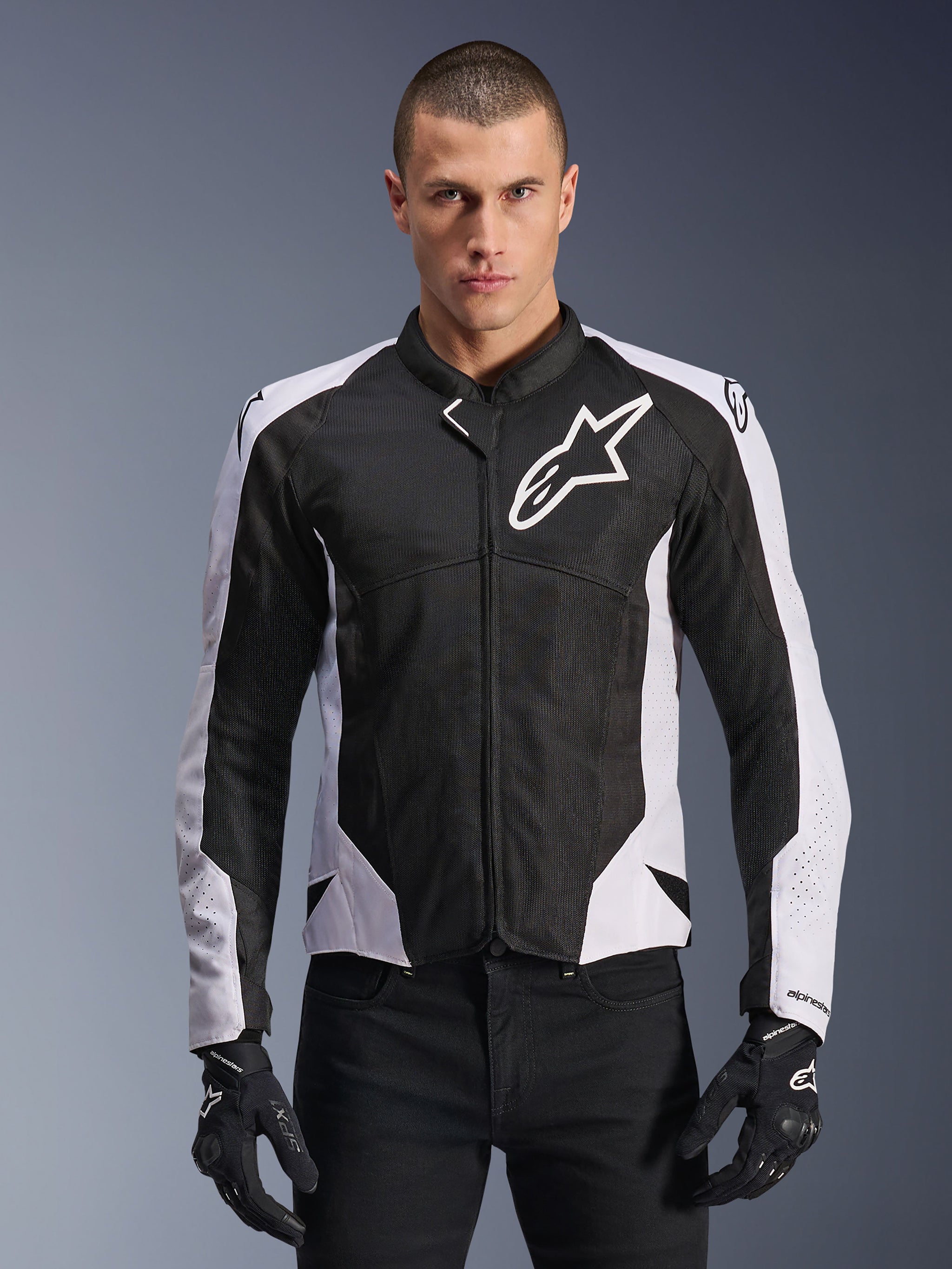 Alpinestars Viper Air V4 Jacket, Motorcycle Racing Jacket, Black and White, worn by rider, tech mesh and textile construction with white shoulder panels, prominent star logo on chest, sport performance design, paired with black riding gloves