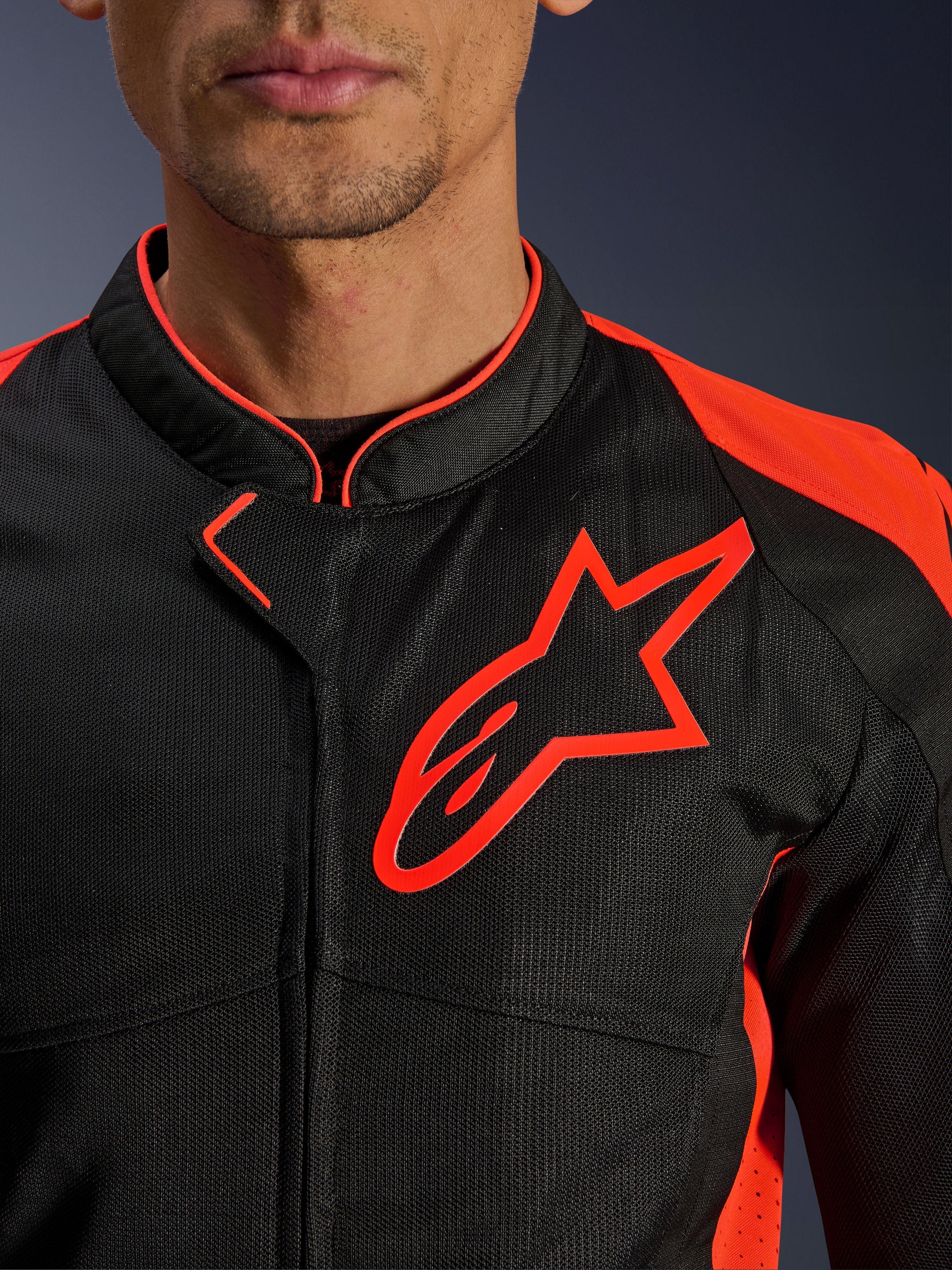 Alpinestars Viper Air V4 Jacket in Red Fluo Black, close-up view of the chest and collar, featuring black tech mesh construction, a prominent red Alpinestars logo, and vibrant red accents on the shoulders.