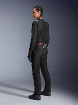 Alpinestars Woman Stella T-Sps Air v2 Jacket, Black and Diva Pink, textile motorcycle jacket shown from a rear-side view, featuring large mesh panels for airflow and white star logo on the back, worn with matching black riding pants, gloves, and boots.