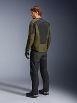 Male model wearing Alpinestars C-1 Air Jacket in Khaki, urban motorcycle jacket, rear view highlighting large black mesh panels on the back, paired with black technical riding pants and gloves, contemporary motorcycle gear for warm weather