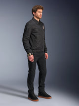 Alpinestars Ignite Air Jacket, Urban Motorcycle Jacket, Black, worn by a model with black pants and black sneakers, featuring a traditional shirt collar, club-inspired graphics on the chest and cuffs, sleek contemporary design with mesh and satin finish