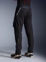 Alpinestars Acteon Pants, Black motorcycle pants, back and side view showing a modern tapered fit, side cargo pocket with logo, vertical white Alpinestars branding on the upper thigh, yellow 'Alpinestars Protects' text on the lower leg, urban contemporary riding gear